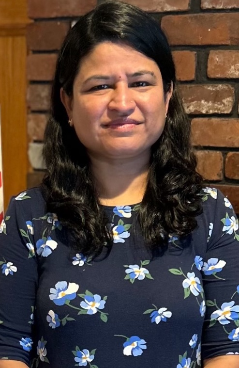 a woman with dark hair smiles at the camera