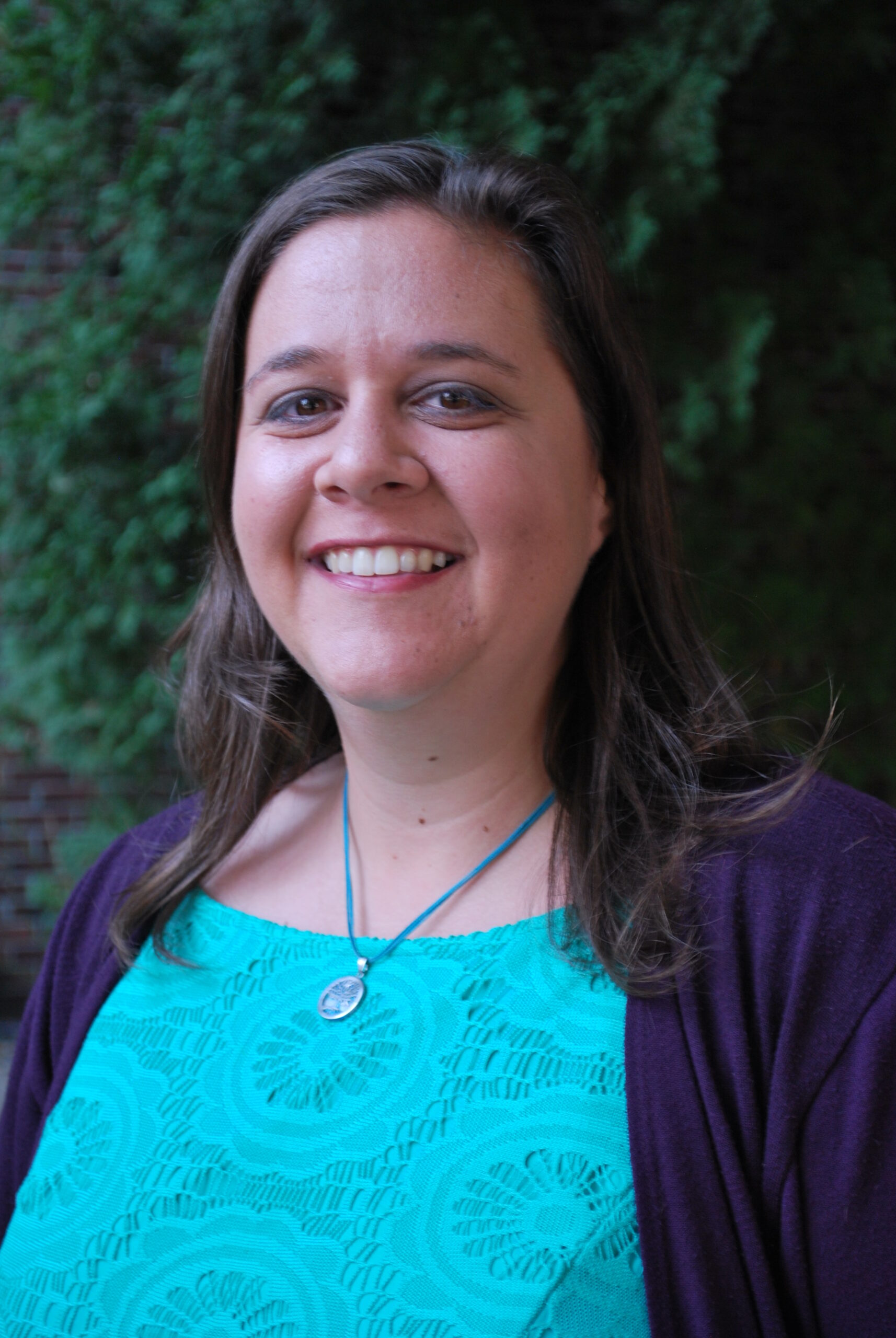 A woman with brown hair smiles at the camera