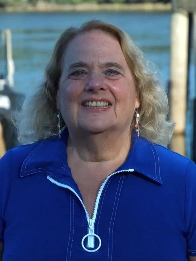 a woman with blonde hair smiles at the camera
