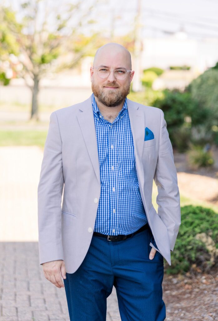 A smiling bearded man in a suit