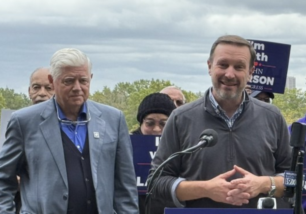 Two men stand behind a podium at a political event