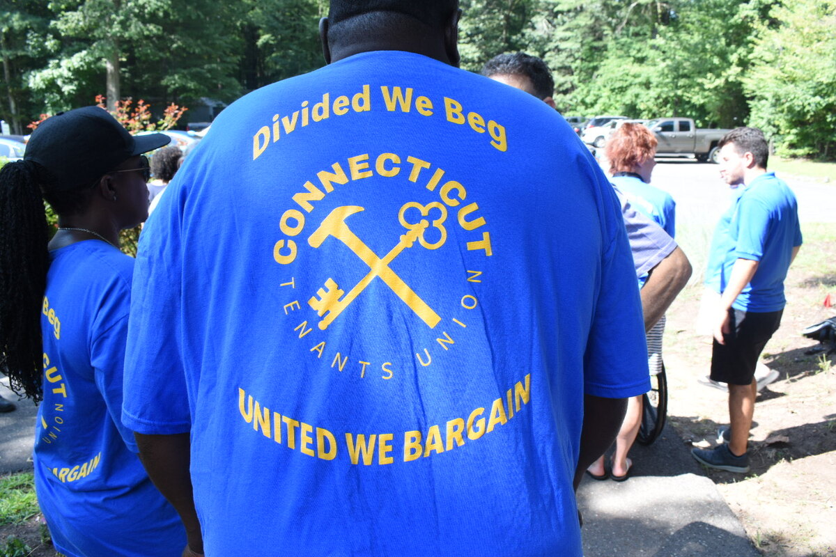 A man with a teeshirt that says "Divided We Beg, United We Bargain"