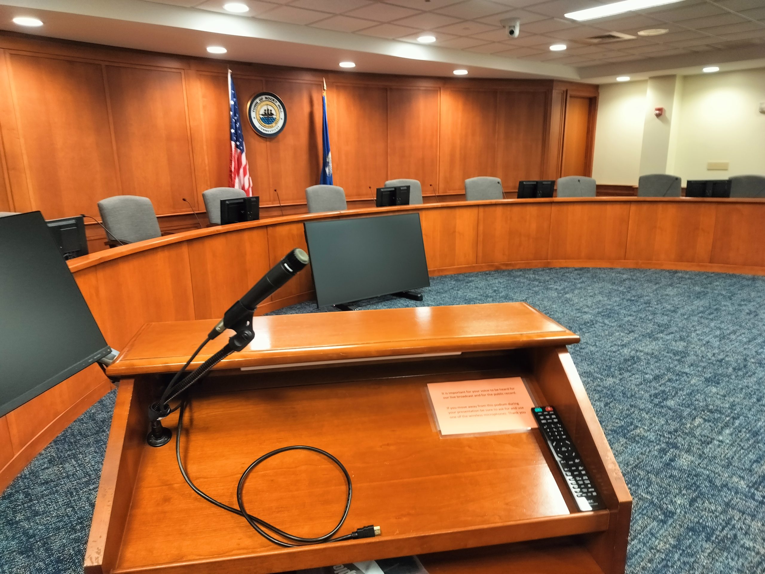 an empty podium with a microphone in front of seats